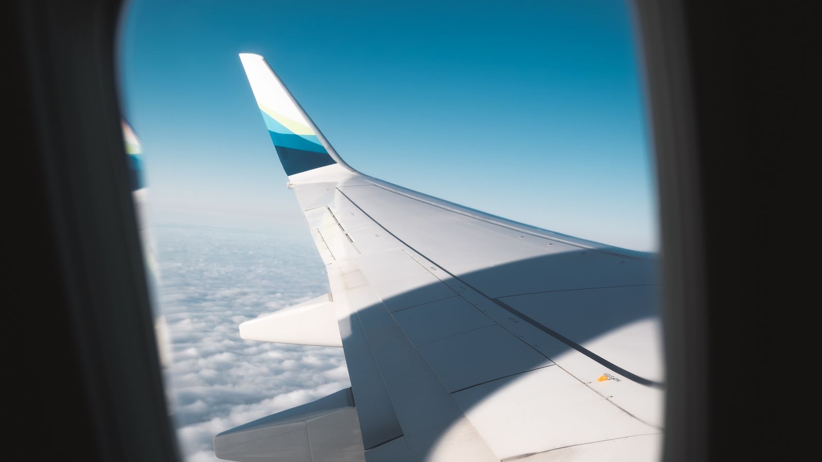 Airplane wing above clouds during a flight